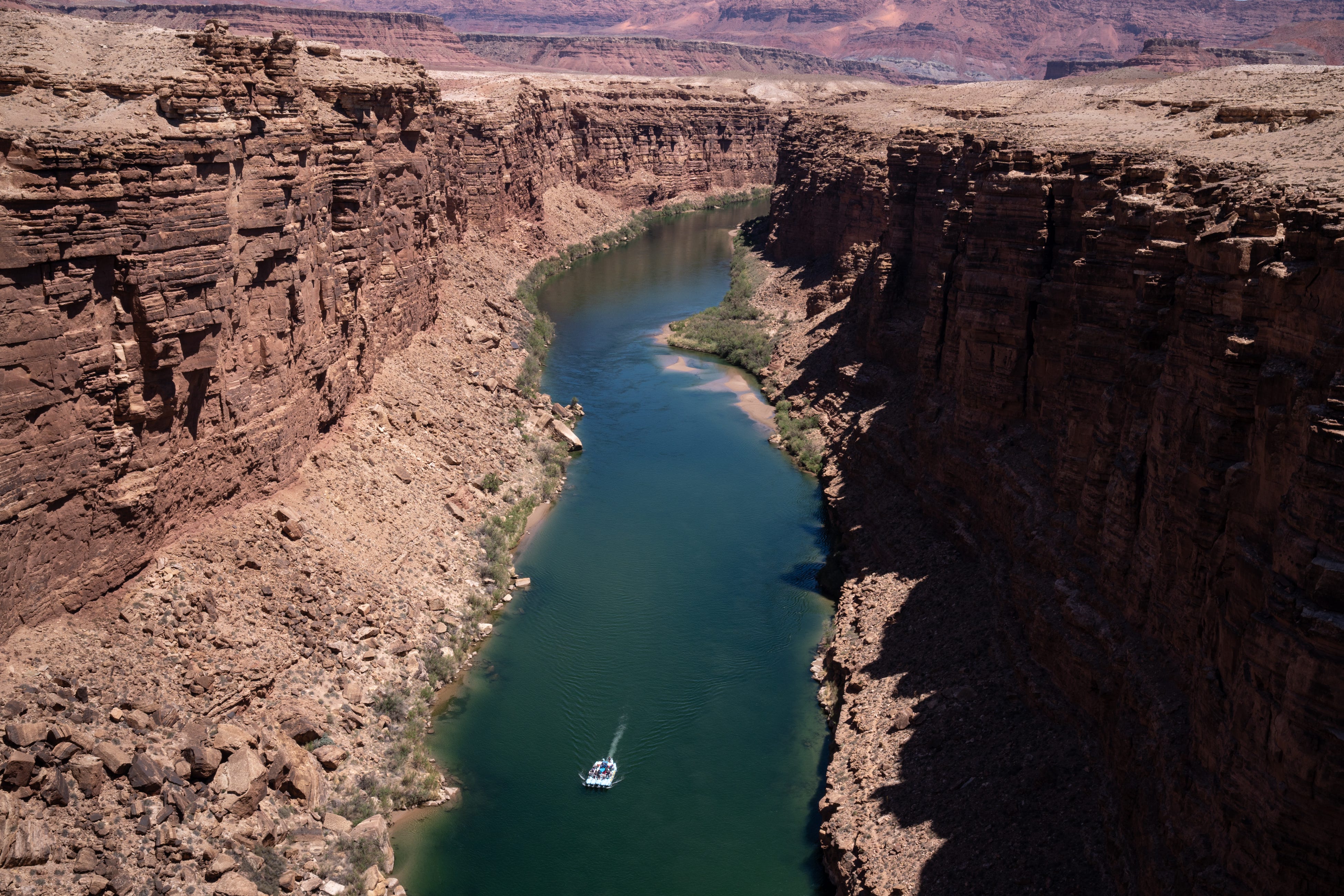 A raft floats down the Colorado River at the start of their journey through the Grand Canyon, May 25, 2022, Marble Canyon, Arizona.