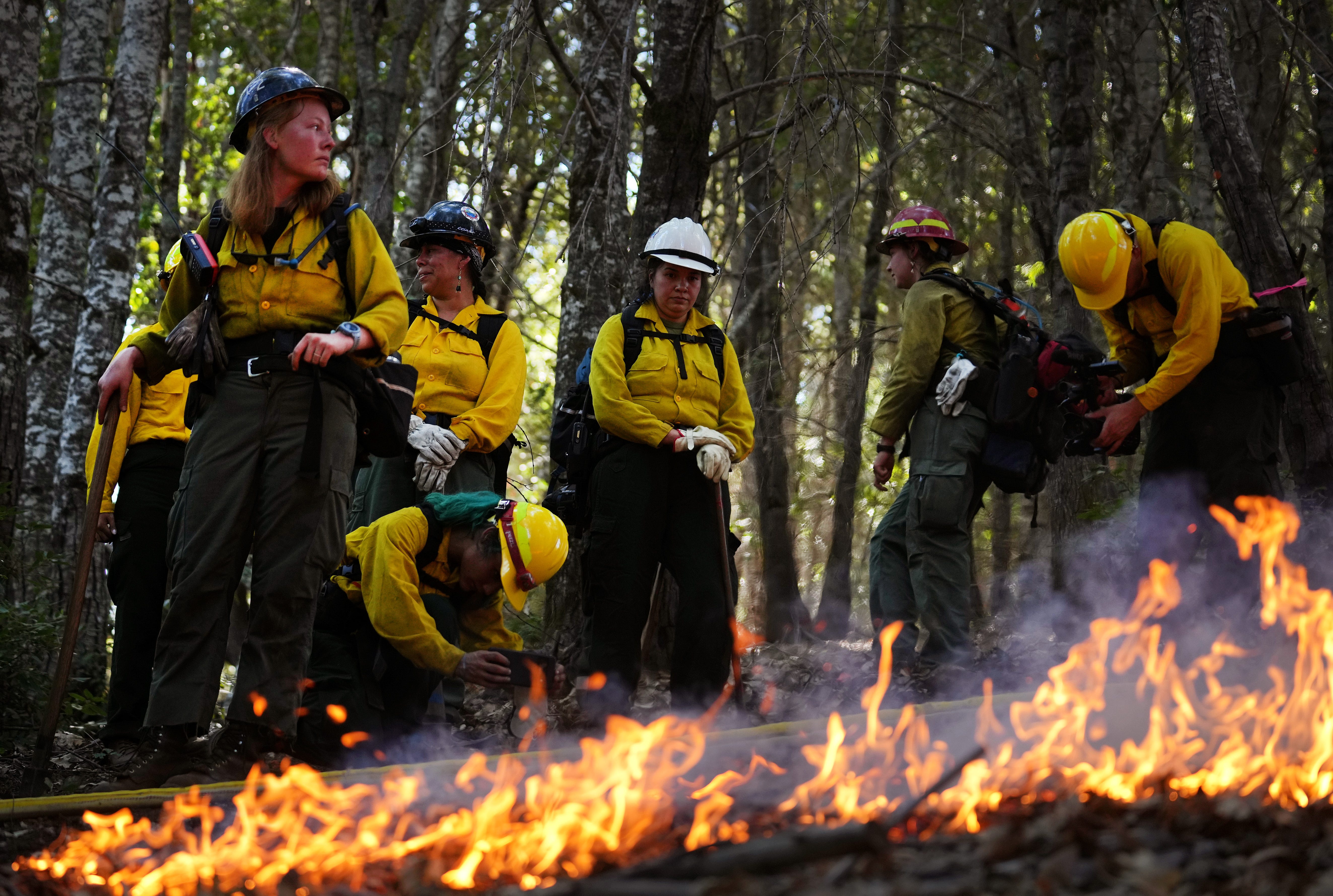 Volunteers set fires during a controlled burn around Karuk ancestral territory, which includes land owned by the U.S. Forest Service and private landowners on Monday, Oct. 3, 2022, as part of an Indigenous Women-In-Fire Training Exchange program.