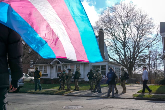 Unidentified men armed with rifles and body armor stand on the sidewalk of East Dominion Boulevard after protesting Holi-drag, an event at the Red Oak Community School, where local drag queens read story books. The event was cancelled due to a safety concerns, the school said on social media.