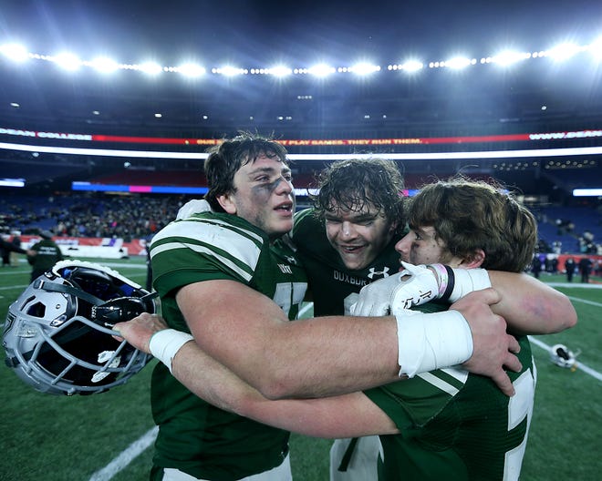 Duxbury's Thomas Sheehan, Duxbury's Alexander Barlow, and Duxbury's Andrew Hunt embrace following their 42-7 win over Grafton in the Division 4 Super Bowl at Gillette Stadium in Foxborough on Friday, Dec.  2, 2022. 