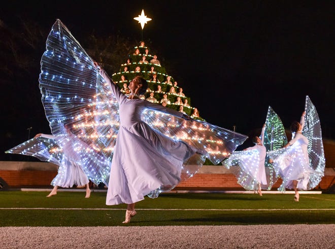 Dancers dressed as angels perform in front of the Belhaven Concert Choir at Jackson's annual Singing Christmas Tree at Belhaven's Bowl Stadium in Jackson, Miss., Friday, December 2, 2022.