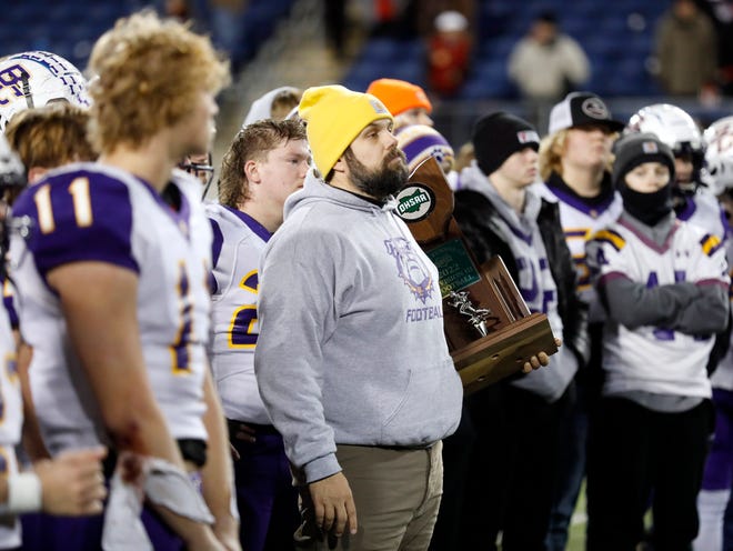 Head coach Jeremy McKinney holds the runner-up trophy following  Bloom-Carroll's 35-14 loss to Canfield in the Division III state championship game on Friday at Tom Benson Hall of Fame Stadium in Canton.
