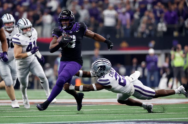 TCU wide receiver Savion Williams (18) runs with the ball as Kansas State safety Drake Cheatum (21) defends during the first half of the 2022 Big 12 titel game at AT&T Stadium.
