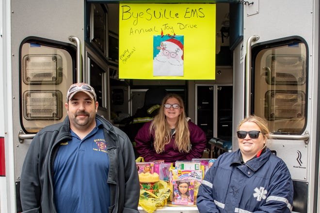 Dustin, Kaylee and Kala Bacon (left to right) man the ambulance at the Byesville Fill-An-Amblunace toy drive event for the Secret Santa program.