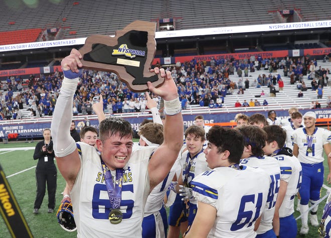 Maine-Endwell's Adam DeSantis (65) and his teammates celebrate their victory over Pleasantville in the state Class B football championship at the JMA Wireless Dome in Syracuse on December 4, 2022.