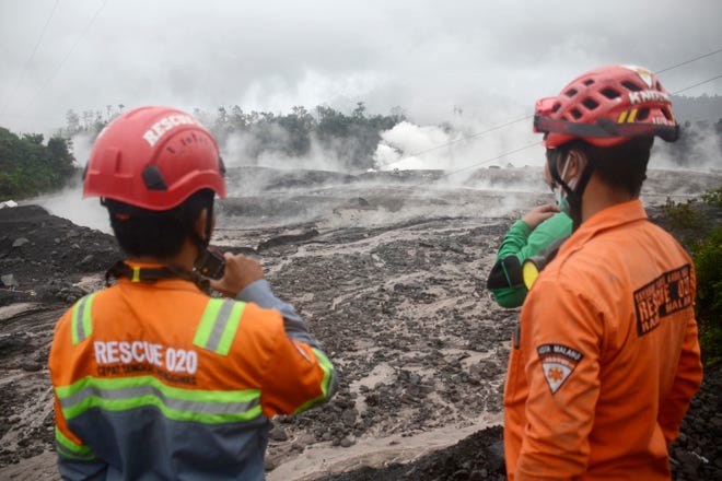 Rescuers monitor the flow of volcanic materials from the eruption of Mount Semeru, in Lumajang, East Java, Indonesia, Sunday, Dec. 4, 2022.