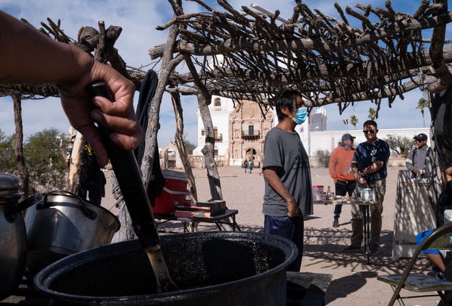 Latoya Norris, left, stirs stew in her food stand at the San Xavier del Bac Mission, Nov. 22, 2022, in Tucson.