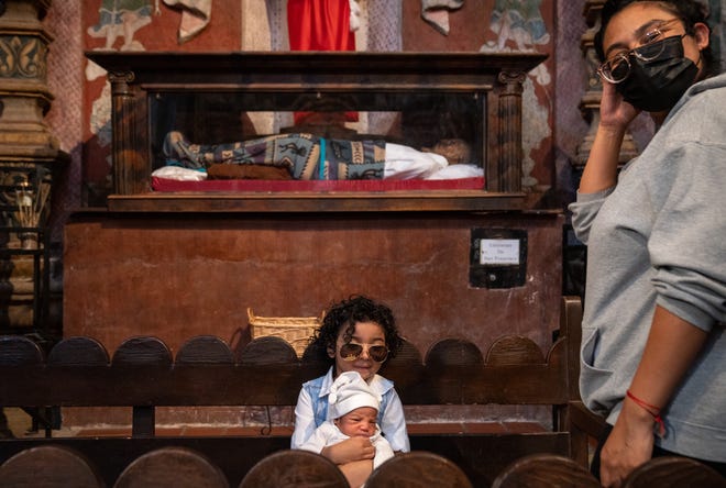 Uriel Pedroza, 4, has his photo taken with his brother, Valentin Pedroza, 9 days old, in the west transept inside the San Xavier del Bac Mission in Tucson Nov. 22, 2022.