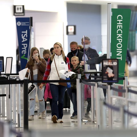 Airline passengers prepare to enter a security che