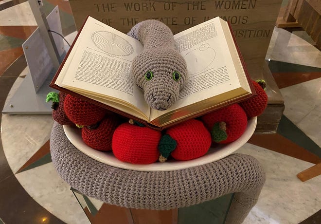 The Satanic Temple of Illinois' 2022 holiday display was dedicated Tuesday, Dec. 6, in the Illinois Capitol rotunda. The display consists of a crocheted snake sitting on a book and a pile of apples crocheted by Satanic Temple members.