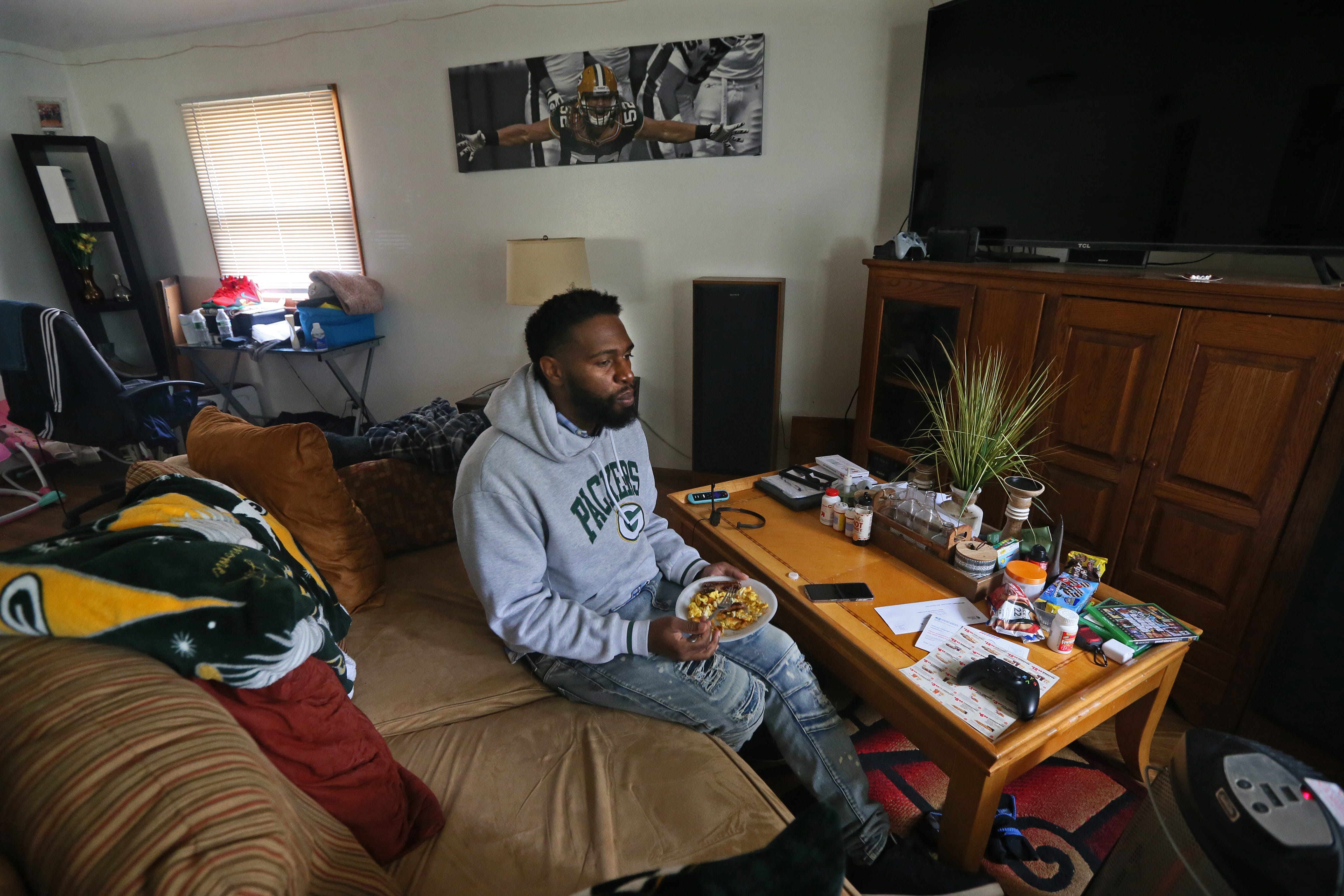 Marlin Dixon has breakfast at his brother’s home, where he moved after being released from Froedtert Hospital. The sofa also serves as his bed. “Even though I am facing homelessness, I have an opportunity to see what I am made of now,” he said.