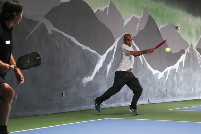 Ronnie Arbaugh, right, hits a shot with doubles partner Ki (James) Ku, left, at the new Pickled Bar indoor pickleball center in Palm Desert, Calif., Dec. 6, 2022.