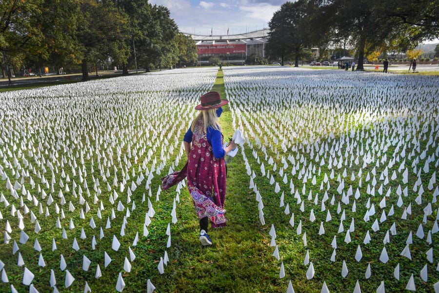 May 12, 2022: The "IN AMERICA: How Could This Happen" project artist Suzanne Firstenberg walks through the installation on the D.C. Armory Parade Ground in Washington, D.C. The project honors each of the nearly 225,000 lives lost in the U.S. due to COVID-19 with a white flag.