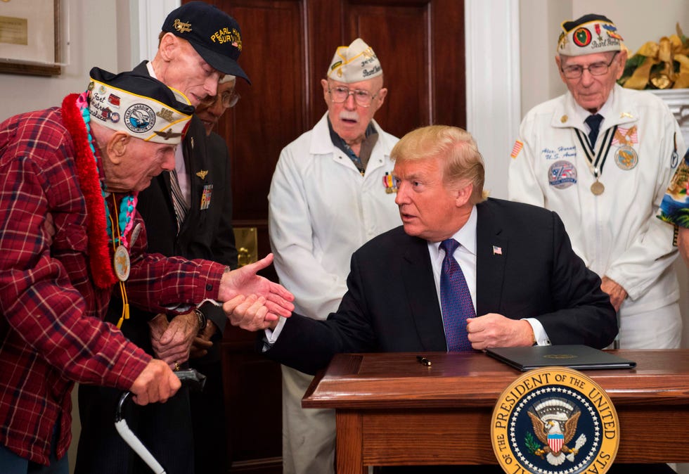 President Donald Trump speaks with Pearl Harbor survivor Lawrence Parry (L), alongside fellow survivors, during an event marking National Pearl Harbor Remembrance Day in the Roosevelt Room at the White House in Washington, DC, December 7, 2017.