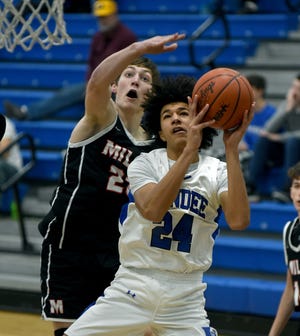 Braiden Whitaker of Dundee drives to the hoop past Trey Chmielewski of Milan Tuesday during a 52-34 Dundee win.