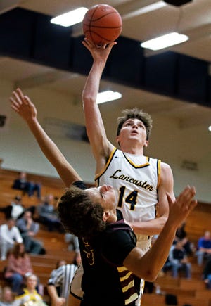 Lancaster's Hayden Allen (14) goes for a lay up over a New Albany defender in varsity boys basketball action at Lancaster High School on Dec. 6, 2022 in Lancaster, Ohio.