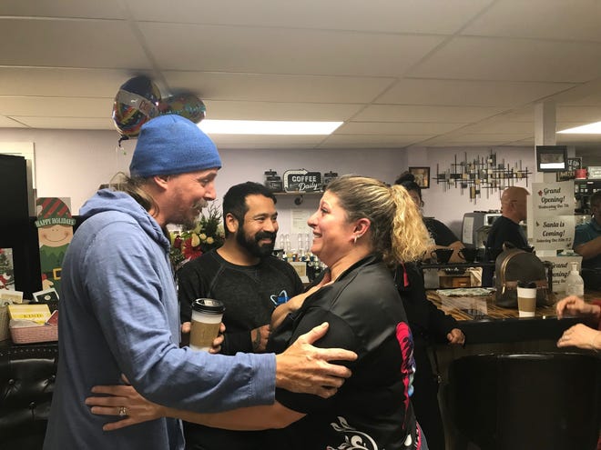 Jessica Backensto, the new owner of Pump & Grind coffee shop, 1290 park Avenue East, celebrates the grand opening with members of the local Richland Area Chamber of Commerce on Wednesday.