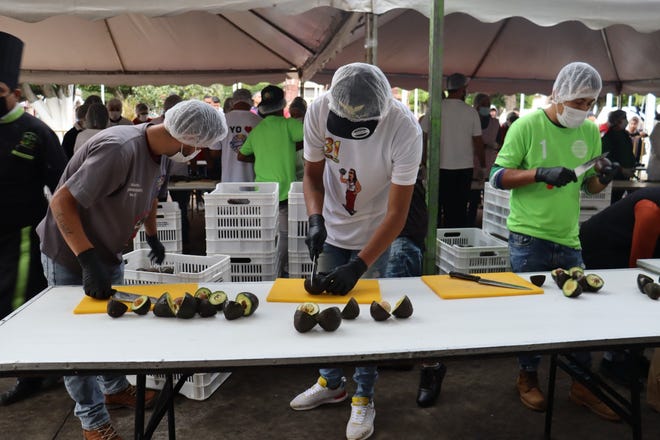 Locals lend a hand cutting avocados for massive guacamole.