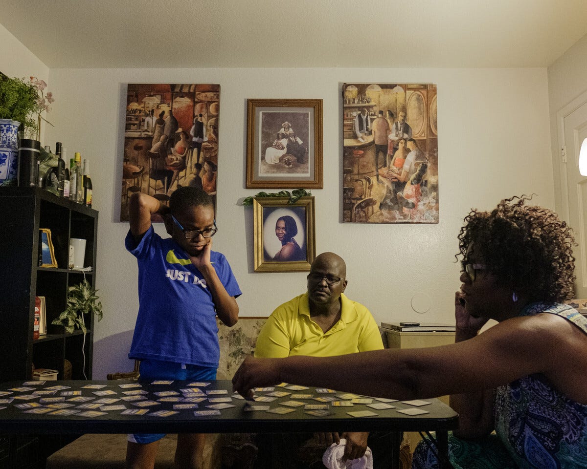 Tressie King, right, plays a matching card game with her husband, Jamel, and their adoptive son at the family’s home in Chandler.