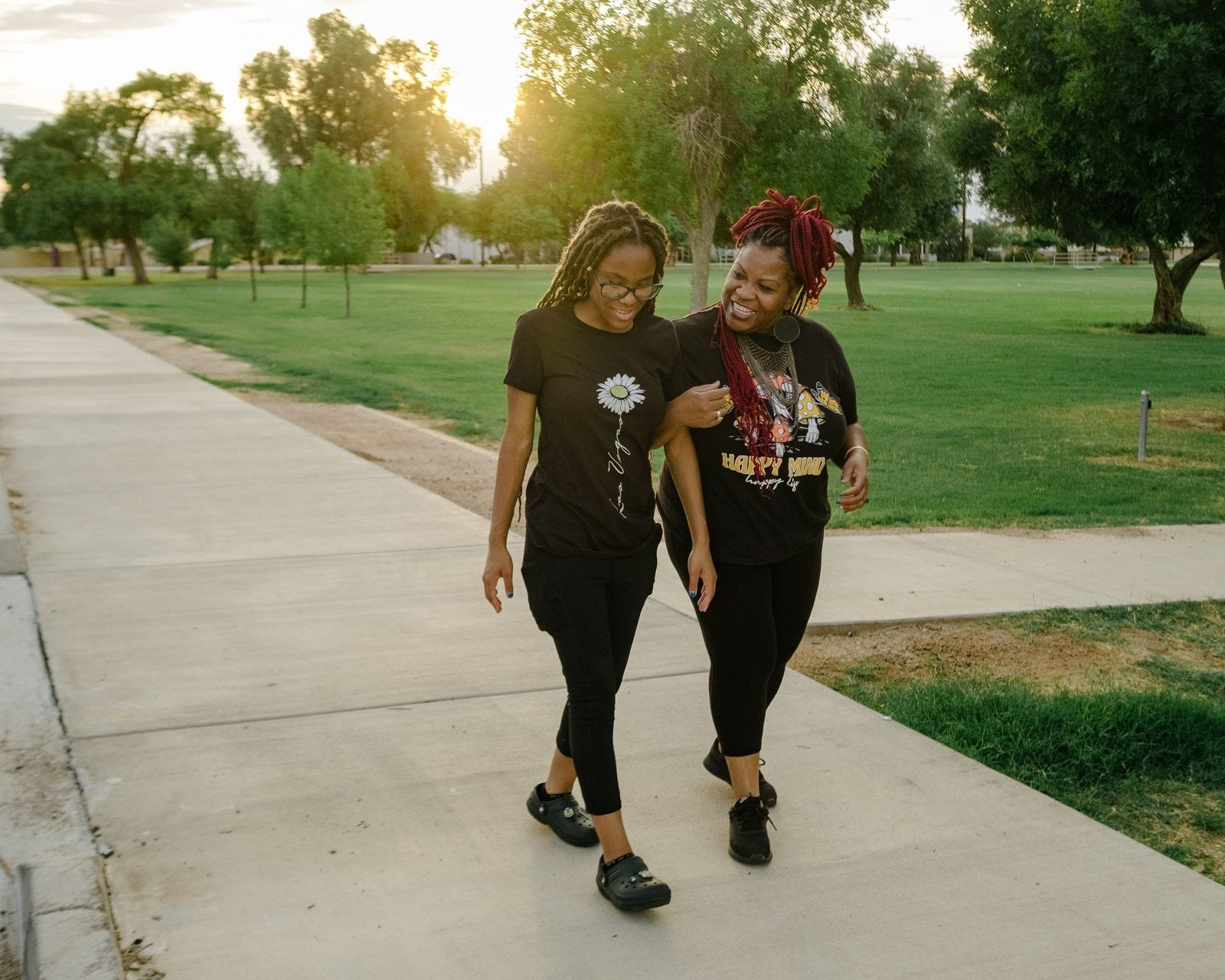 Dana Burns (right) walks with Tierra, whom Burns has raised as her daughter, at a park near their home in Phoenix.