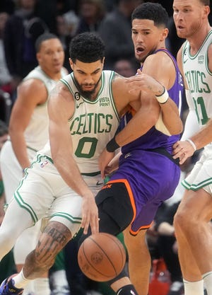 Dec 7, 2022; Phoenix, Arizona, USA; Boston Celtics forward Jayson Tatum (0) drives past Phoenix Suns guard Devin Booker (1) at Footprint Center. Mandatory Credit: Joe Rondone-Arizona Republic