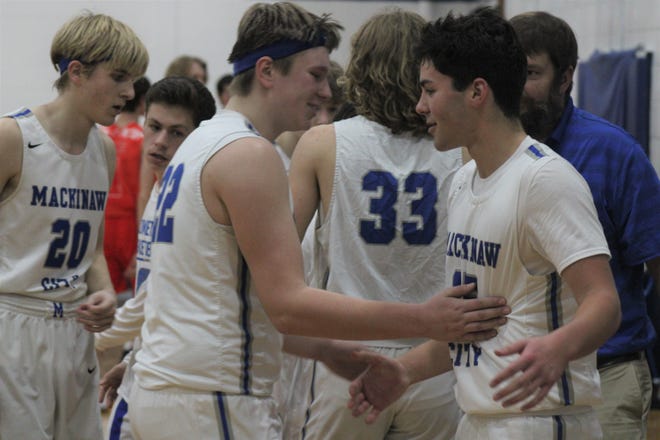 Mackinaw City senior Cooper Whipkey (right) and junior Lucas Bergstrom (22) celebrate after defeating the Onaway Cardinals in a boys basketball contest in Mackinaw City on Thursday night.
