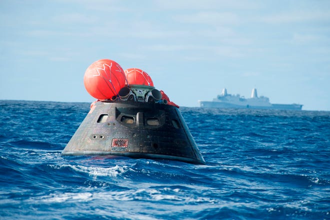 NASA's Orion spacecraft floats in the Pacific Ocean after splashdown from its first flight test in Earth orbit in 2014. NASA, the U.S. Navy and Lockheed Martin coordinate efforts to recover Orion and secure the spacecraft in the well deck of the USS Anchorage.