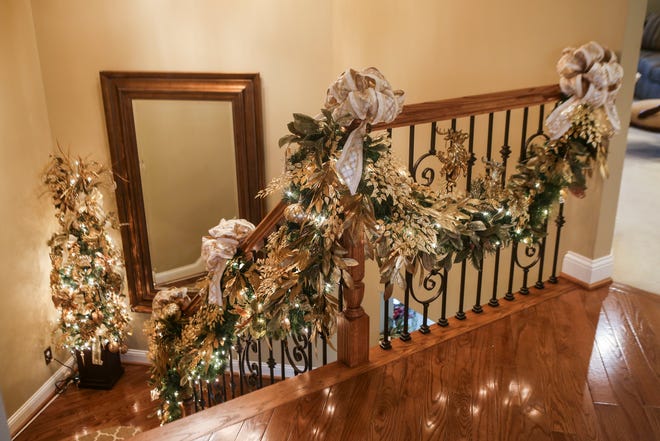 The stairs to the walkout basement at Mary Jane Hollinsworth's home features a long garland of green, gold and silver.