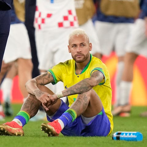 Brazil's Neymar sits on the pitch at the end of th