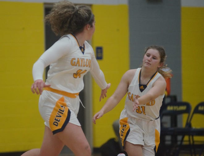 Avery Parker (left) and Alexis Shepherd (right) high five after a made basket during a high school basketball matchup between Gaylord and Cadillac on Friday, December 9.