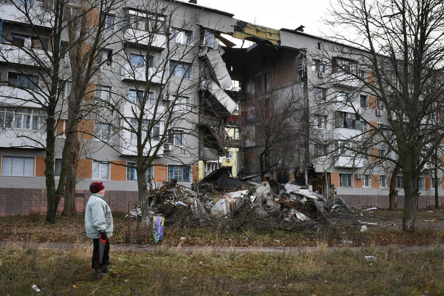 A woman passes by an apartment building damaged following by Russian shelling in Bakhmut, the site of the heaviest battles with the Russian troops, in the Donetsk region, Ukraine, Sunday, Dec. 11, 2022.