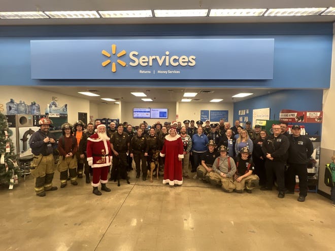 First responders pose for a photograph with Santa and Mrs. Clause and Walmart staff Dec. 4 during the 10th annual Shop with a Hero event.