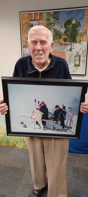 Fred Drotar holds one of his photographs. Drotar is the first in a new series of Artists of the Month offered by the Monroe Art League.