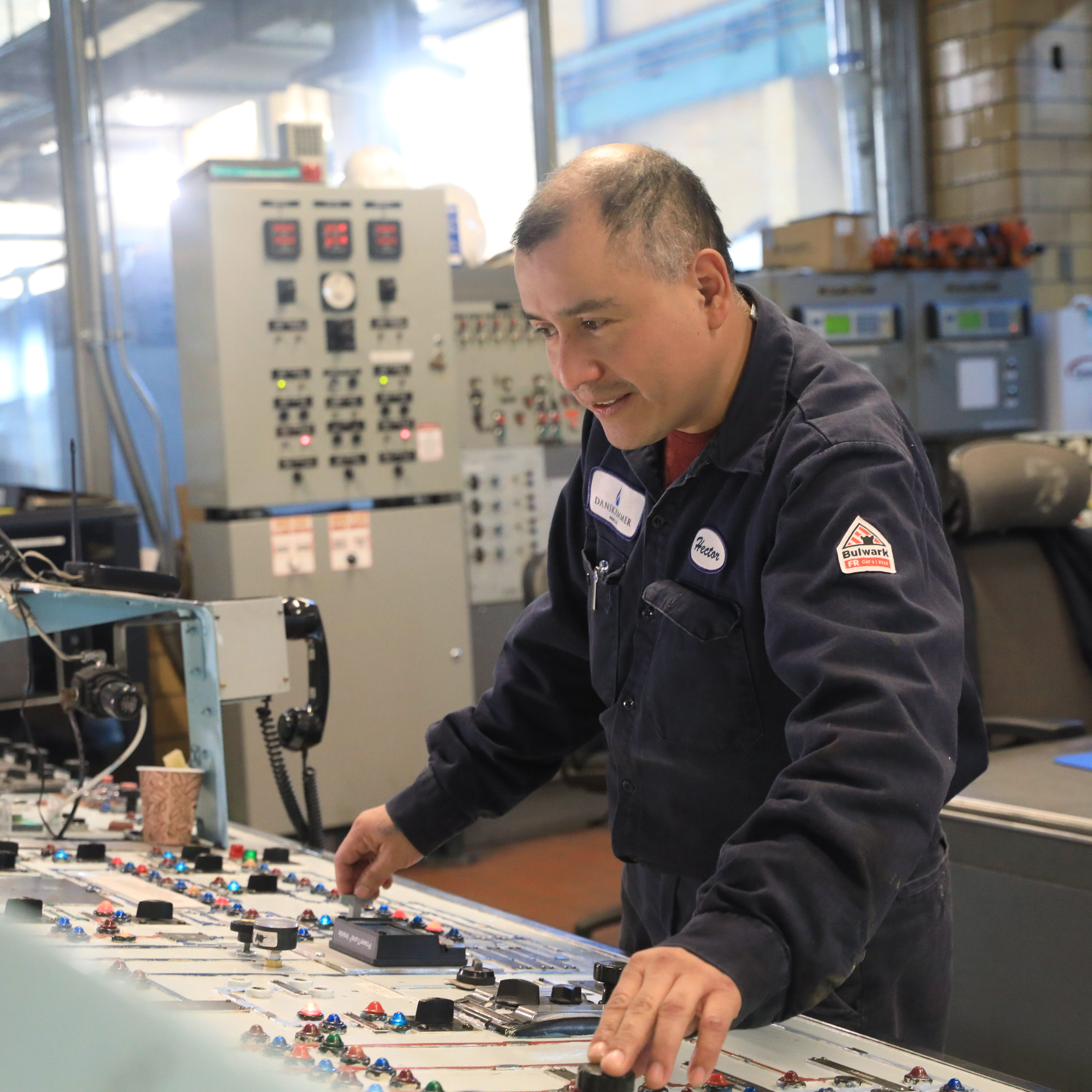 First class control operator Hector Martinez at the control panel for a turbine inside the Danskammer power plant on December 9, 2022. The plant uses natural gas to produce steam which spins the turbines and creates electricity. 