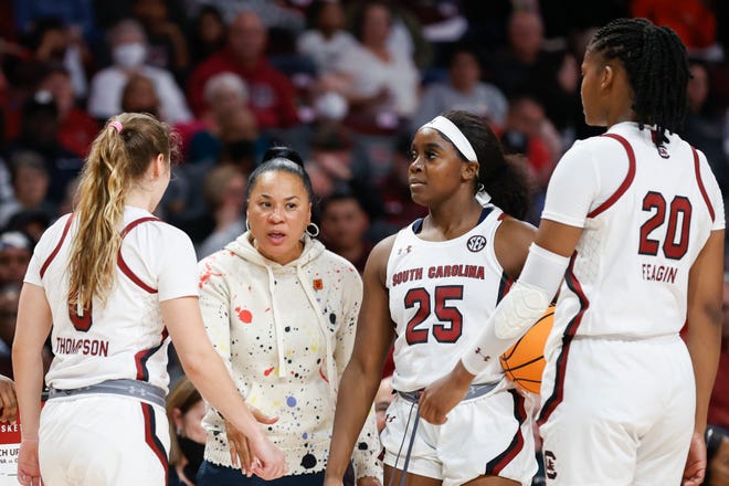 South Carolina head coach Dawn Staley talks to guards Olivia Thompson (0) and Raven Johnson (25) and forward Sania Feagin (20) during a timeout in the second half of an NCAA college basketball game against Liberty in Columbia, S.C., Sunday, Dec. 11, 2022. South Carolina won 88-39. (AP Photo/Nell Redmond)
