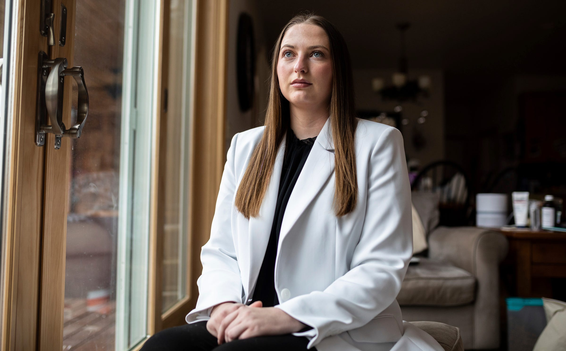 Michigan State University alumna Hannah Smith, 25, sits inside her home in Genesee County, Michigan, on Thursday, Dec. 8, 2022. Smith filed a complaint with the Office for Civil Rights alleging Michigan State mishandled her sexual harassment case.