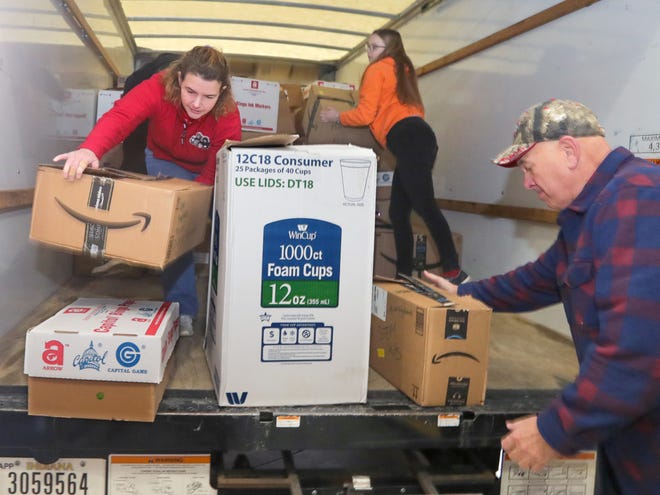 Ashley Natale, Taylor McCarthy and Curt Mayle, members of the Children's Toy Fund, unload a truck with 3,715 items for patients at Akron Children's Hospital.