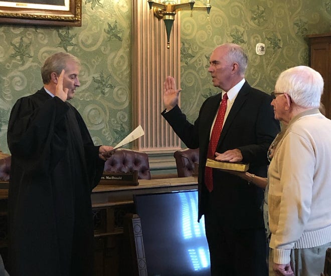 Justice Brian Zahra (left) administers the oath of office to Jim DeSana of Carleton (center), a new representative for House District 29. DeSana’s father, former state senator and Wyandotte Mayor James DeSana (right), looks on. The Rev. John Hedges, pastor of St. Stephen Catholic Church, New Boston, also attended.