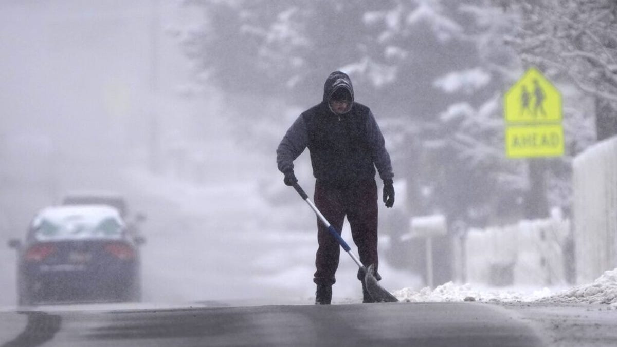 A man clears his driveway of snow from an overnight storm in Provo, Utah on December 13, 2022.