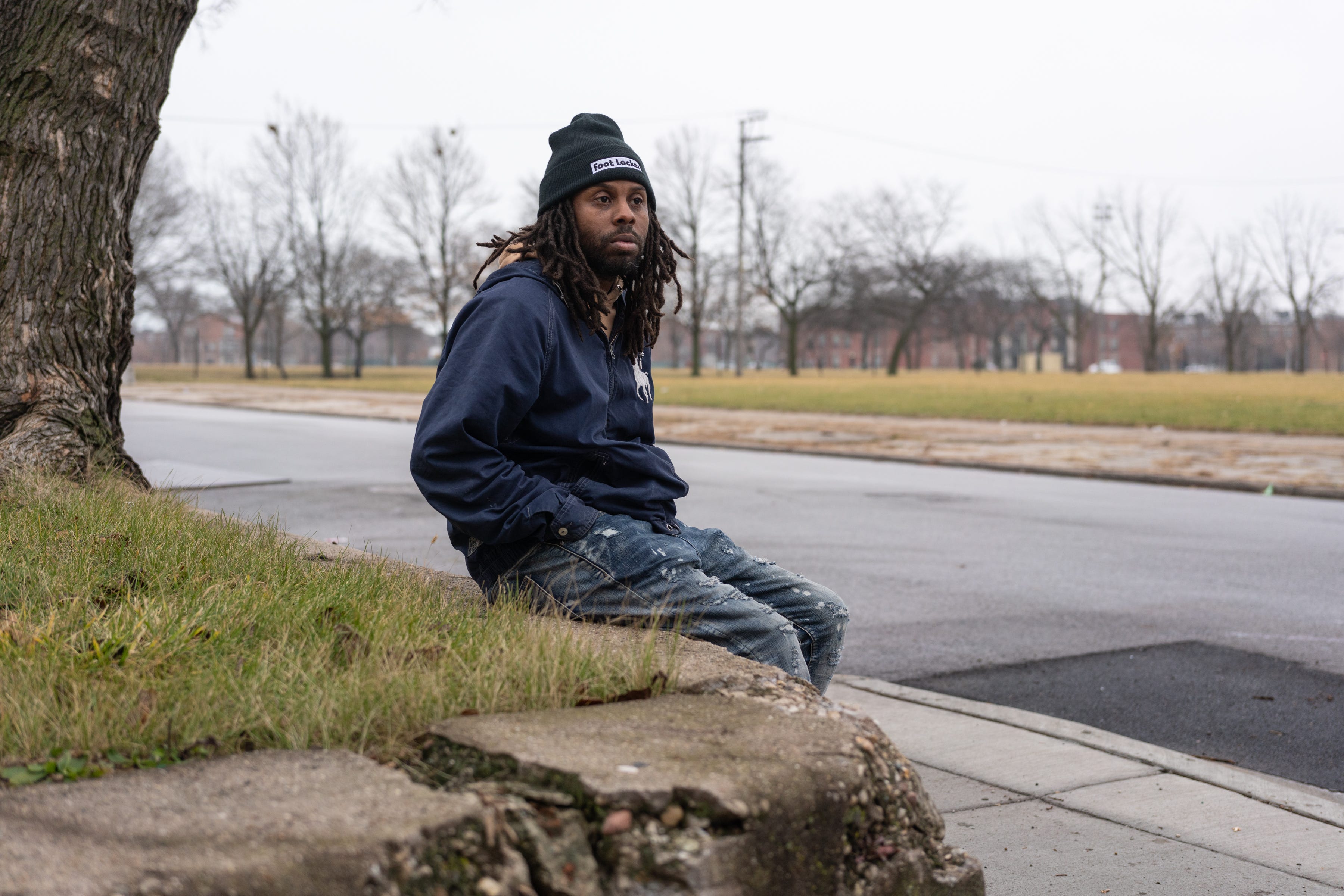 Ed Wilkins, 42, sits across from the former Ida B. Wells Homes site in Chicago where he once lived, on Dec. 10, 2022.