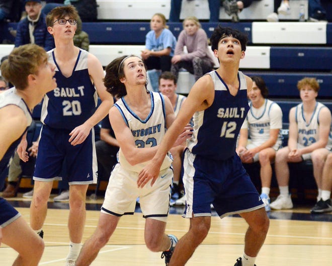 Sault Ste. Marie's Nathan Koepp (12) and Easton Fitzner (20) watch a free throw with Petoskey's Brandon Klingelsmith (middle) during the second half on Tuesday.