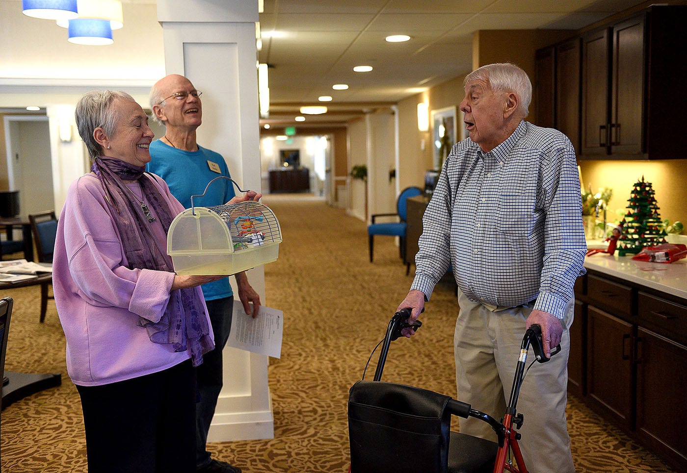 Ken Snow speaks with fellow RiverWoods Manchester residents Ann and Karl Hentz in an upstairs lobby.
