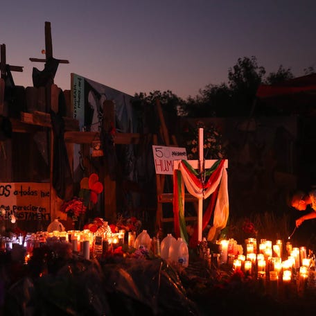 June 30, 2022: A boy lights candles at a memorial site in San Antonio, Texas. The site is dedicated to 53 migrants that died of heat-related illness in an abandoned semitrailer in Southwest San Antonio on June 27, 2022.