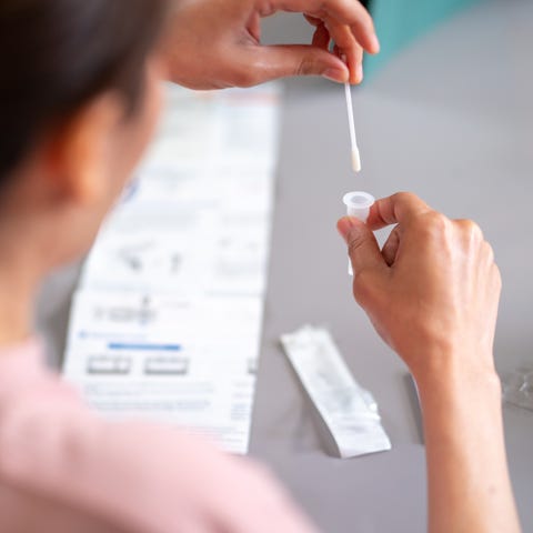 Woman using rapid antigen test kit for self test C