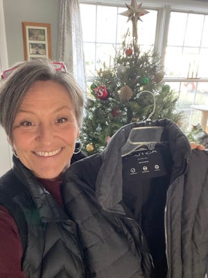 Lynda Nickelson, a member of North Star Five Real Estate Team, holds one of the coats to be donated to a local school or charity.