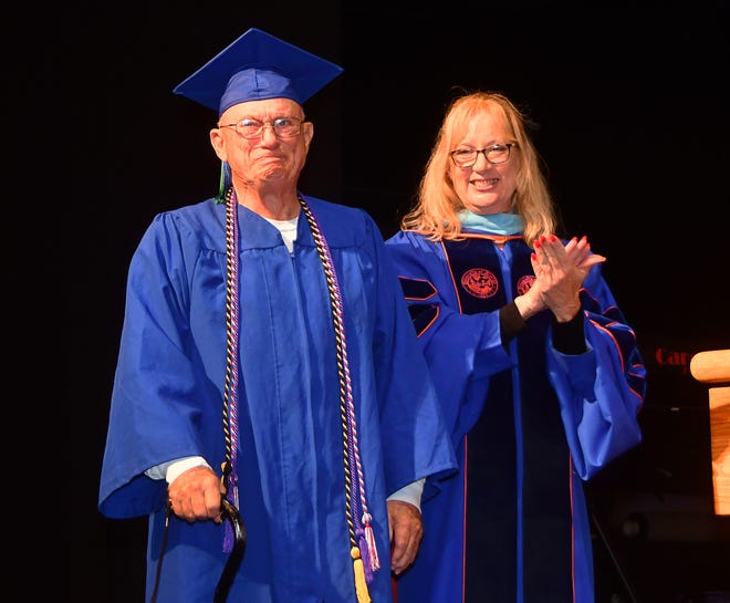 Đại úy John Stein Jr. xúc động khi Tiến sĩ Barbara Kennedy, trưởng khoa sinh viên, EFSC, đọc thành tích của mình trong buổi lễ tốt nghiệp mùa thu của Đại học Bang East Florida vào thứ Năm tại Trung tâm King.