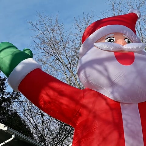 A Santa blowup stands outside a home