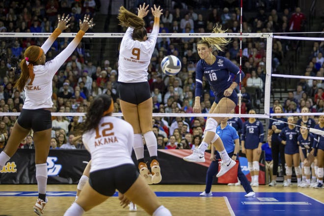 San Diego's Katie Lukes sends a spike across the net during the second set of Thursday night's NCAA volleyball semifinals in Omaha, Neb. Texas dropped the first set but swept the next three to advance to Saturday's national championship match against Louisville.