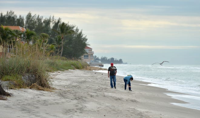 Beachgoers walk at Turtle Beach Park on Friday, Dec. 16, 2022.