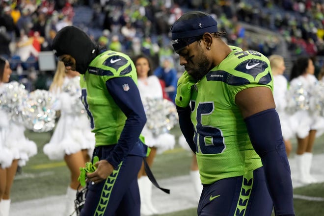 Seattle Seahawks cornerback Coby Bryant, left, and linebacker Jordyn Brooks walk off the field after an NFL football game against the San Francisco 49ers in Seattle, Thursday, Dec. 15, 2022. (AP Photo/Stephen Brashear)